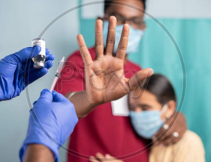Selective Focus On Coronavirus Vaccination Bottle - Concept Of Parents Vaccine Hesitancy For Children, Showing By Saying No Or Stop Gesture To Vaccine With Hand At Hospital.