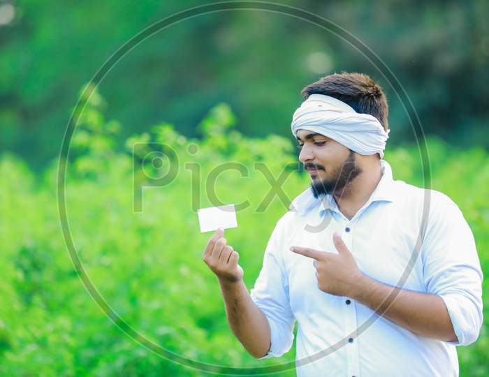 Indian farmer holding ATM card in hand, cotton farming, happy farmer