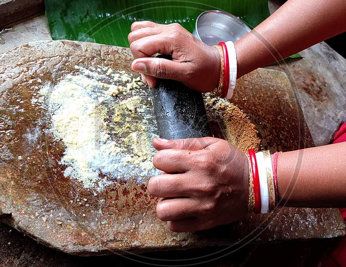A Traditional Rock Grinder To Mash Spices And Herbs.Chilli And Spices Being Crushed On A Traditional Indian Vintage Grinding Stone