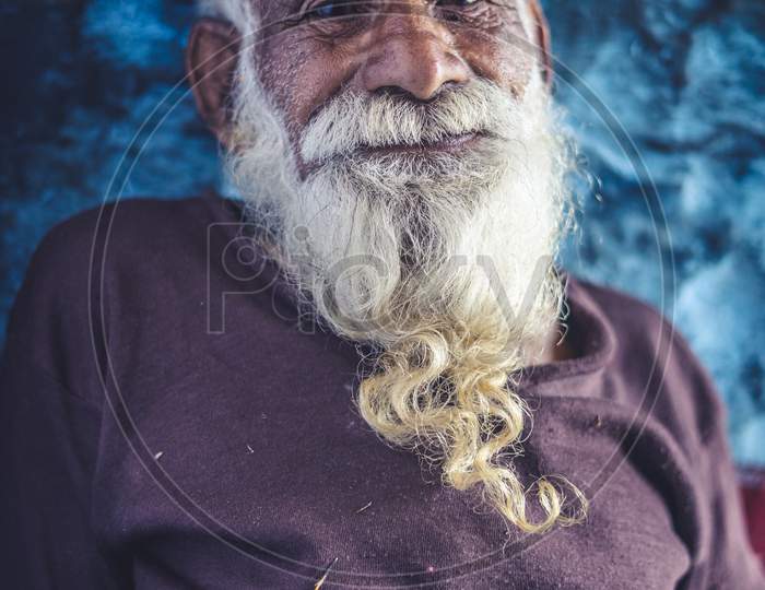 Portrait Of An Old Indian Man, Old Aged Man With Wrinkles On His Face Smiling Into The Camera.