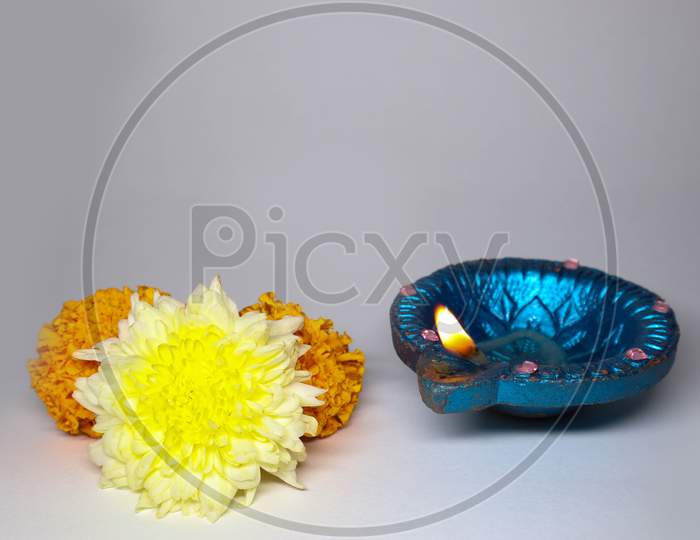 Celebrating Indian Festival Of Light Diwali. Close-Up Of Traditional Diya Oil Lamps And Flowers On A White Background.
