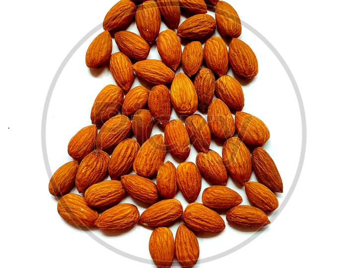 Shape of christmas tree made of almond nut on white background. Top view, copy space. X-Mas holidays concept