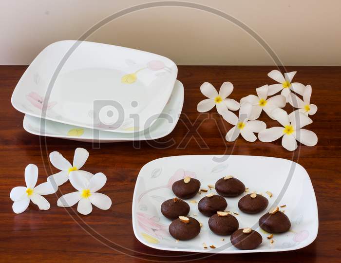 Dark chocolate truffle or cocoa balls or pralines on dark wood background. Also called cocoa peda in India, this is a high angle view.