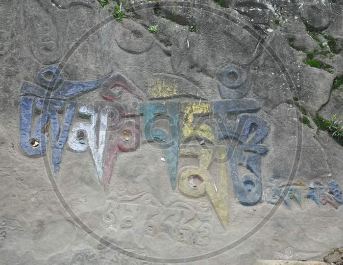 Om Mani Padme Hum (Buddhist mantra) written Tibetan script on rock in Rewalsar lake (Tso Pema), Himachal Pradesh, India