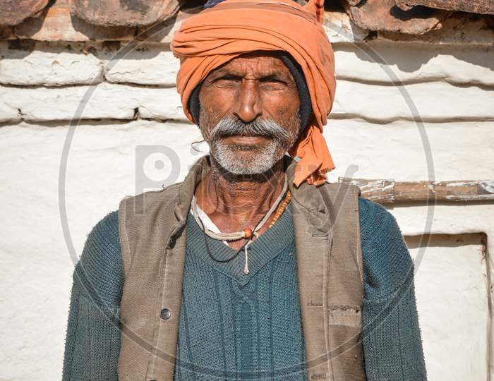 TIKAMGARH, MADHYA PRADESH, INDIA - SEPTEMBER 28, 2021: An old Indian man smiling and looking at the camera.