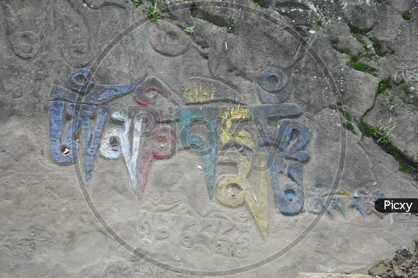Om Mani Padme Hum (Buddhist mantra) written Tibetan script on rock in Rewalsar lake (Tso Pema), Himachal Pradesh, India