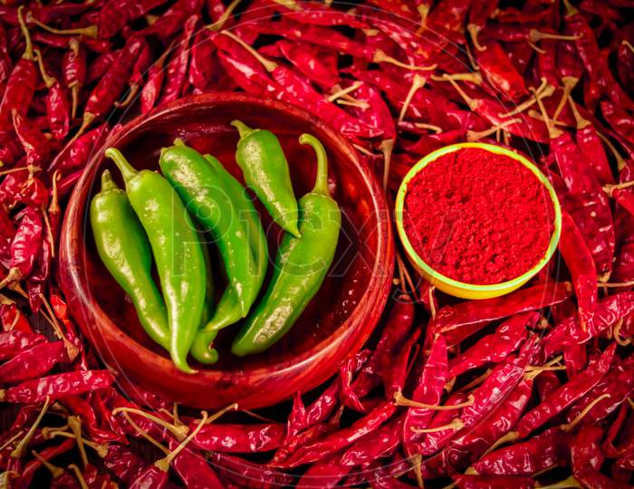 Chili Powder With Green Chillies Is On The Table And Dried Red Chillies Are Falling From Above,Hot Dried Chili Peppers On Wooden Table
