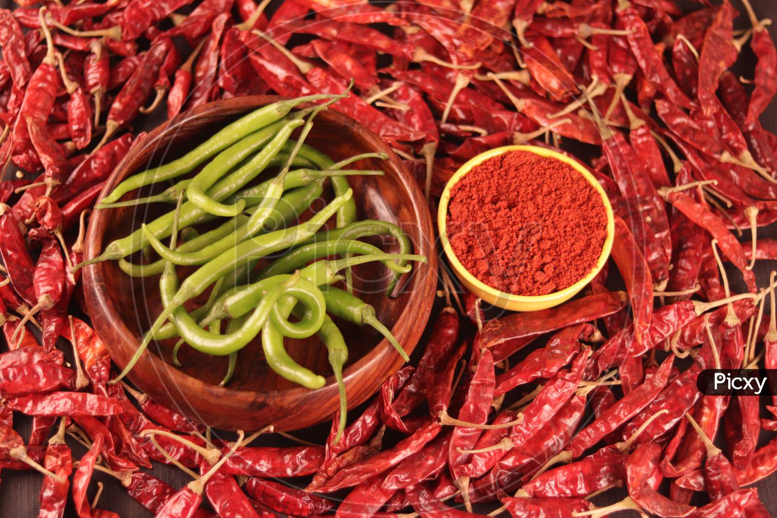 Green Chillies Are Falling In A Wooden Bowl With Chili Pepper Powder And Dried Chili As A Food Background,Mexican Hot Chili Pepper,