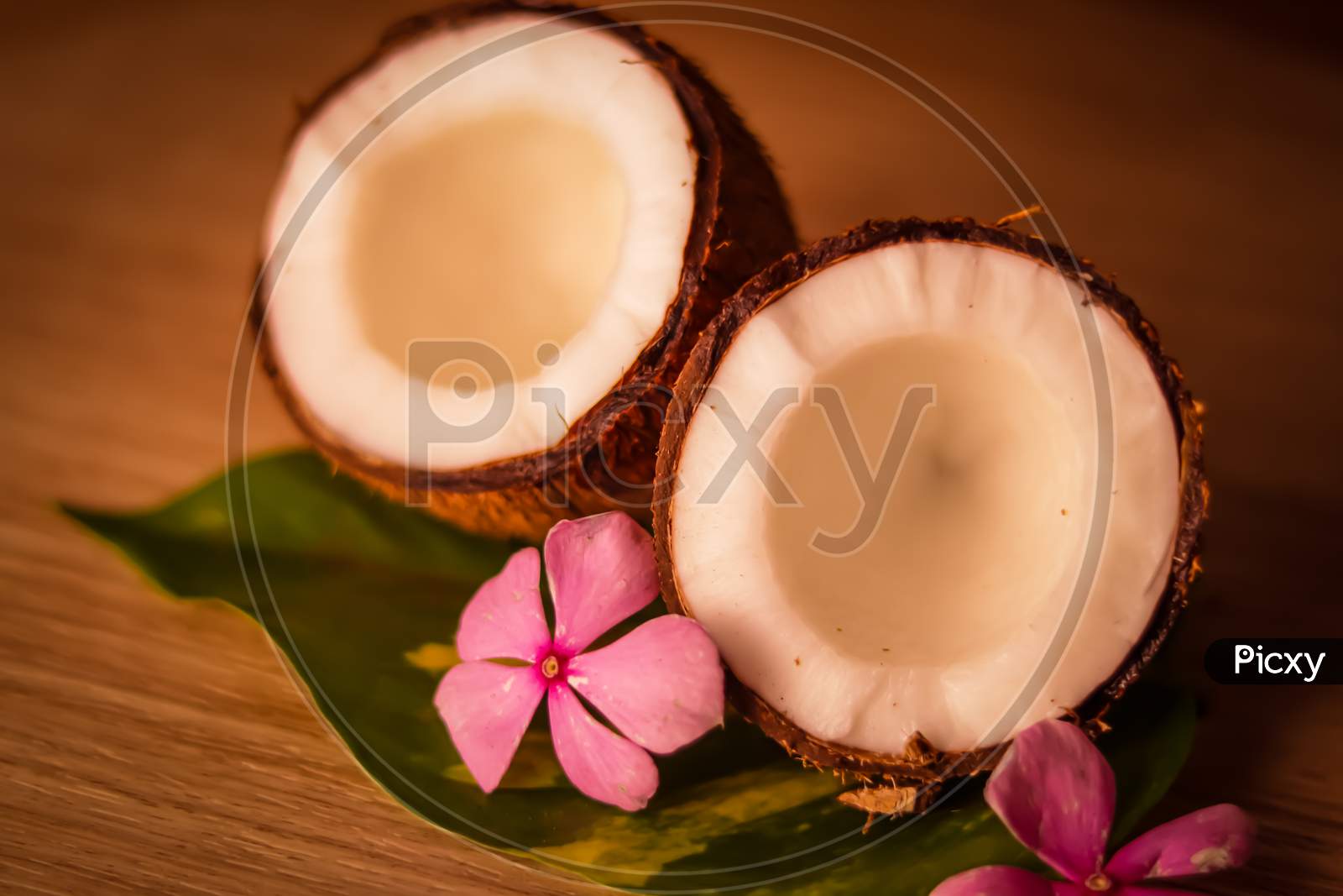 Coconut And Coconut Milk On Wooden Table,Coconut With Leaves And Flower,Glasses Of Coconut Milk,,Selective Focus On Subject,
