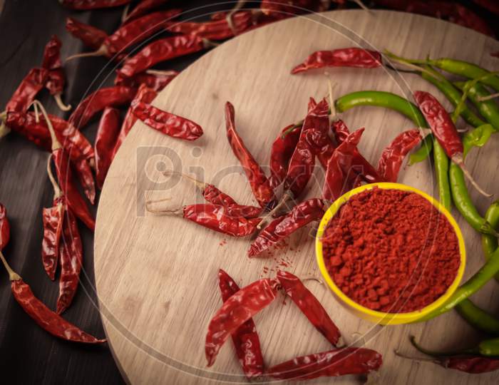 Chili Peppers Family,Green Chili Chili Powder And Dried Red Chili Are Rolling On A Table,Healthy Chili Powder And Chili Peppers