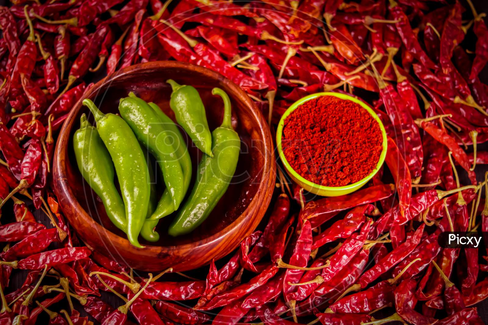 Dried Chili Pepper In Wooden Bowl On The Wooden Table With Chili Pepper Powder In Yellow Bowl,Used As Hot Spice,