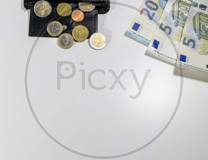 European money with black wallet on white desk as white background with different euro coins and euro bank notes poverty investment financial management and income business plans need for housekeeping