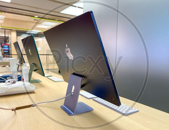 Cologne, Germany - September 30th 2021: A german photographer visiting an Apple Store in a shopping mall, collecting information and taking pictures of the all new Apple iMac 2021 in different colors.