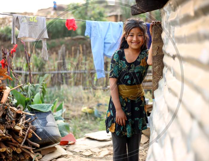 A shy, rural girl smiling and looking into the camera. Rural life photo.