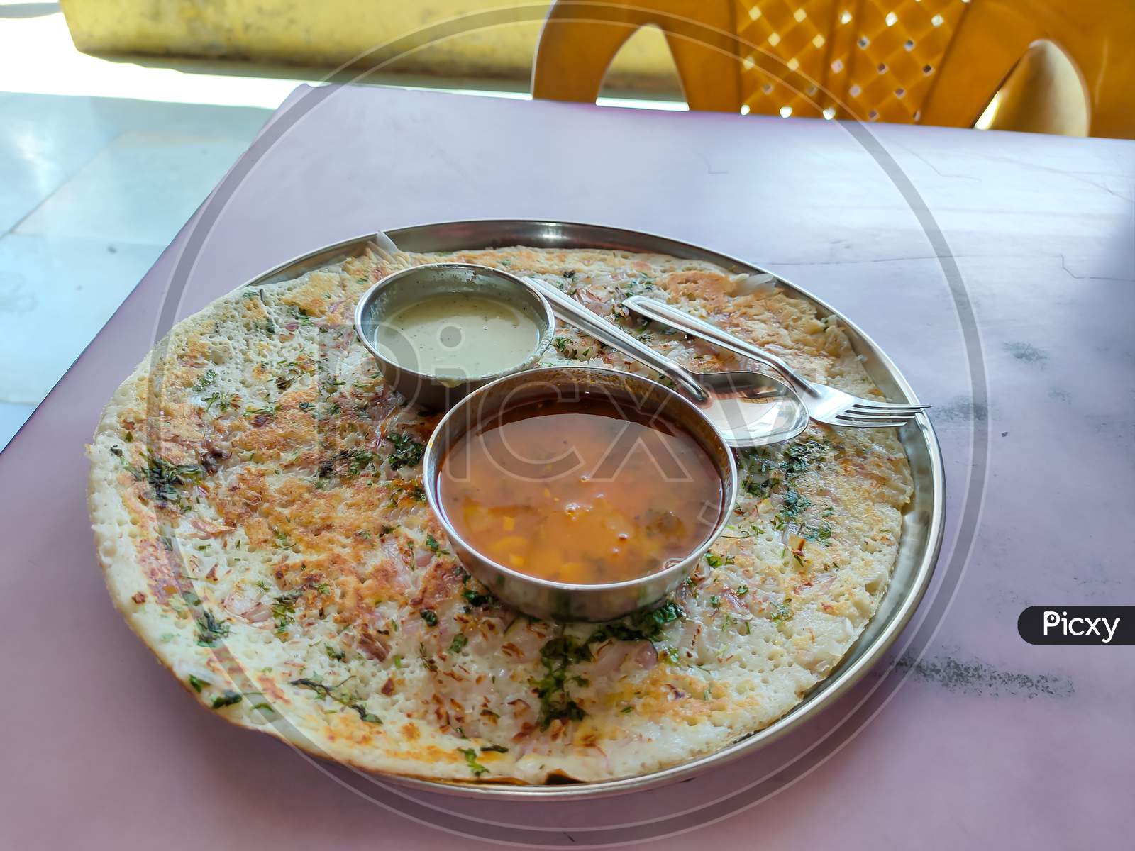 onion uttapam is south indian dish with coconut chutney, sambar