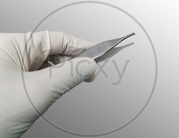 Surgeon Holding Adson Brown Forceps With Gloved Hand. Selective Focus
