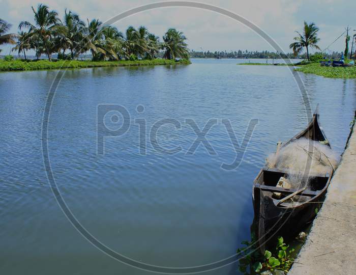 View From The Bangs Of A River With A Small Fishing Boat