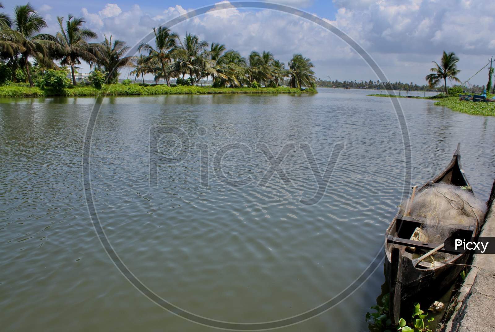 View From The Bangs Of A River With A Small Fishing Boat