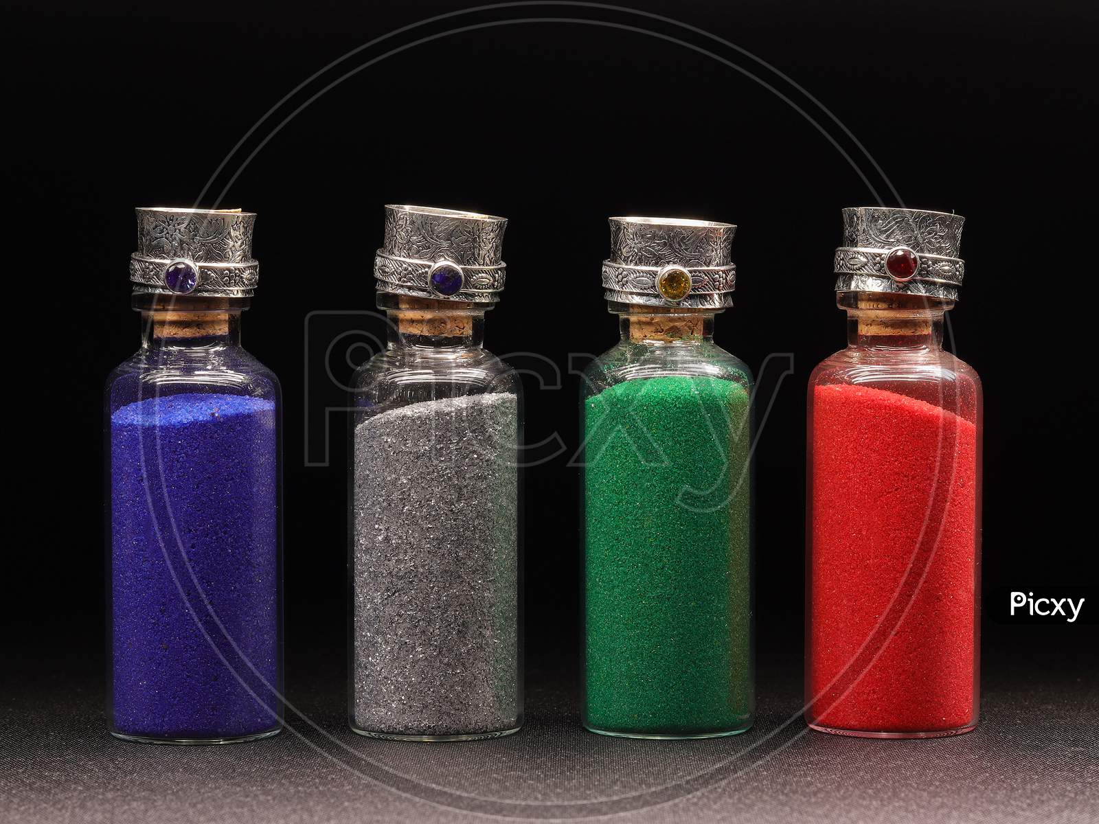 Colorful Glitter In Pots Over Black Background.