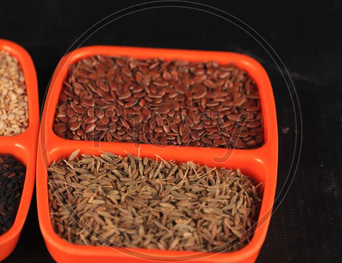 Brown Flax Seed With Cumin Seeds In Oregon Bowl,Indian Spice Mix In One Plate,Organic Flax Seeds In Ceramic Orenge Plate With Caraway Seeds, Cumin Seeds In Plate