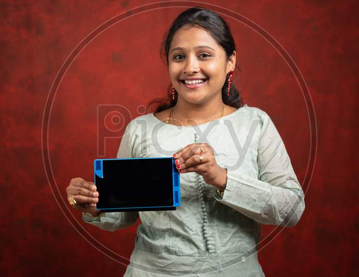 Happy Indian Woman Holding Tab By Looking Camera - Concept Online Advertisement And Shopping Promotion During Festival Season.