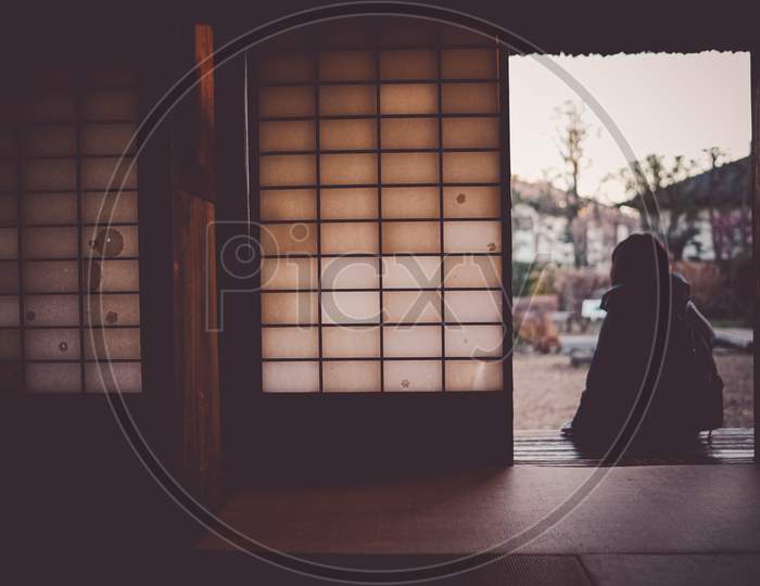 Woman Sitting On The Edge Of A Japanese House