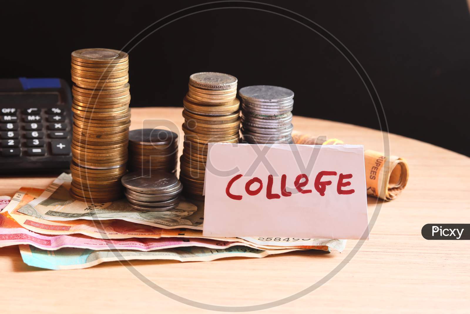 Jar With Label College And Money On The Table,Money Saving,Man Hand Holding Stack Of Coins Money And Glass Jar With Coins And Graduates Hat Label As Education,Education Or Savings Concept,