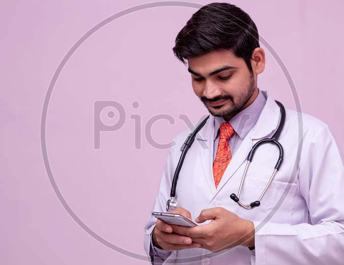 Young Male Doctor Holding Smartphone.