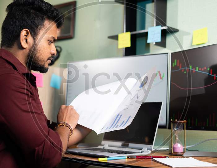 Trader Analysing Stock Market Data From Papers By Looking Monitor - Concpet Of Planning Investment, Money Making And Reading Financial Report.