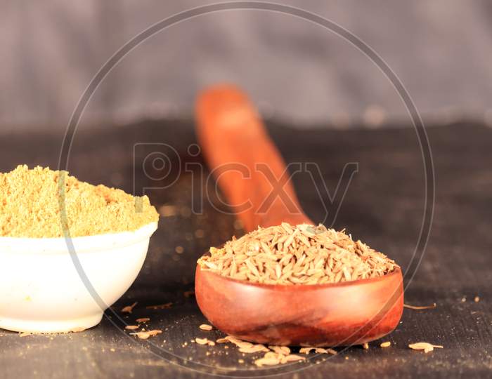 Cumin Powder And Caraway Plant With Carvi Seeds On Wooden Spoon, White Bowl In Cumin Powder,Carvi Seeds On Wooden Spoon,