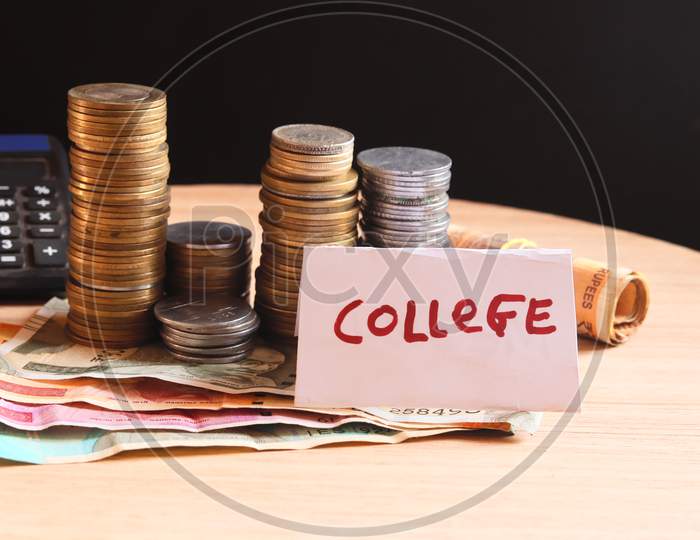 Jar With Label College And Money On The Table,Money Saving,Man Hand Holding Stack Of Coins Money And Glass Jar With Coins And Graduates Hat Label As Education,Education Or Savings Concept,