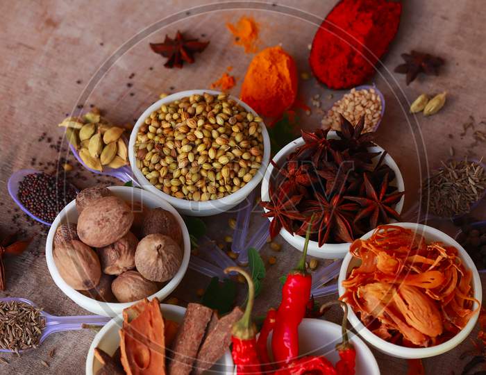 Colorful Herbs And Spices For Cooking,Indian Spices,Indian Spices On Wooden Table,Indian Cuisine. Top View Flat Lay,Indian Bay Leaf, Garam Masala, Mace, Javitri, Nutmeg, Jaiphal, Star Anise,