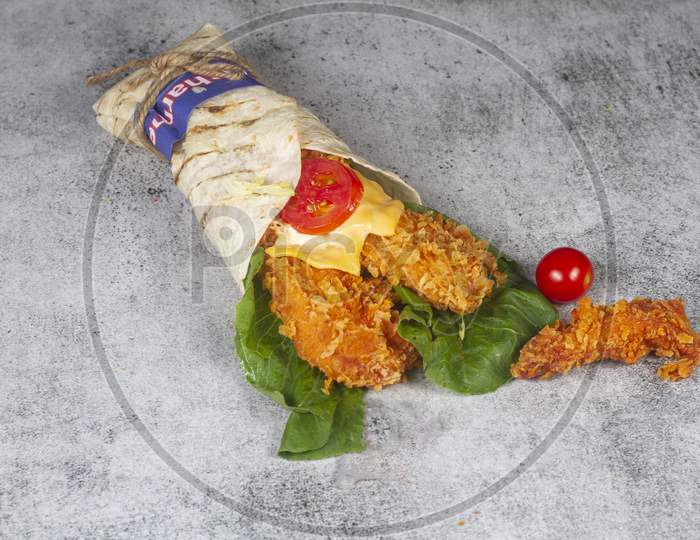 Fresh Fried Chicken Roll With Fresh Tomatos, Salad, Cheese And Onions Isolated On Bright Blue Background. Side View.Selective Focus
