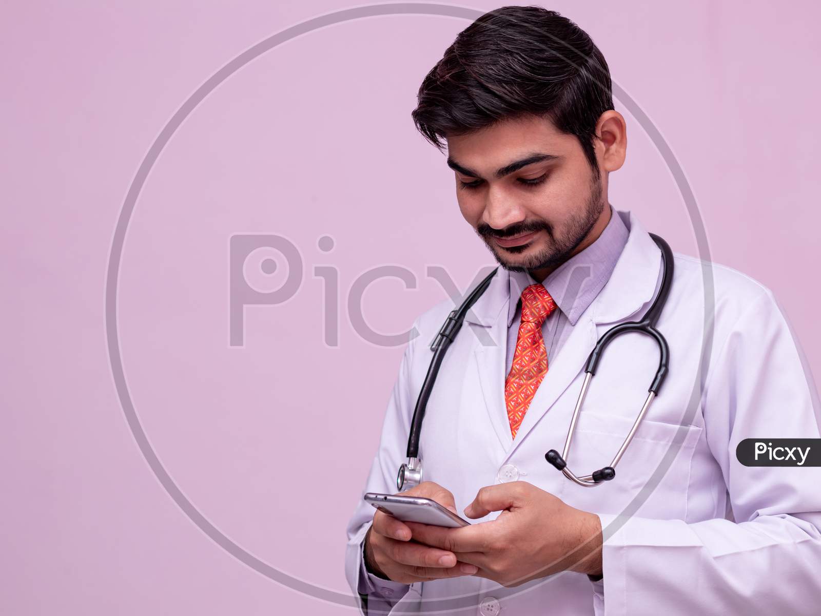 Young Male Doctor Holding Smartphone.