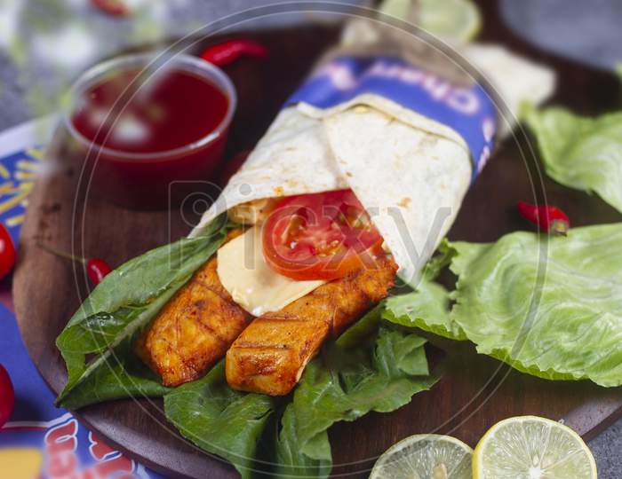 Fresh Grilled Chicken Roll With Fresh Tomatos, Salad, Cheese And Onions Isolated On Bright Blue Background. Side View.Selective Focus