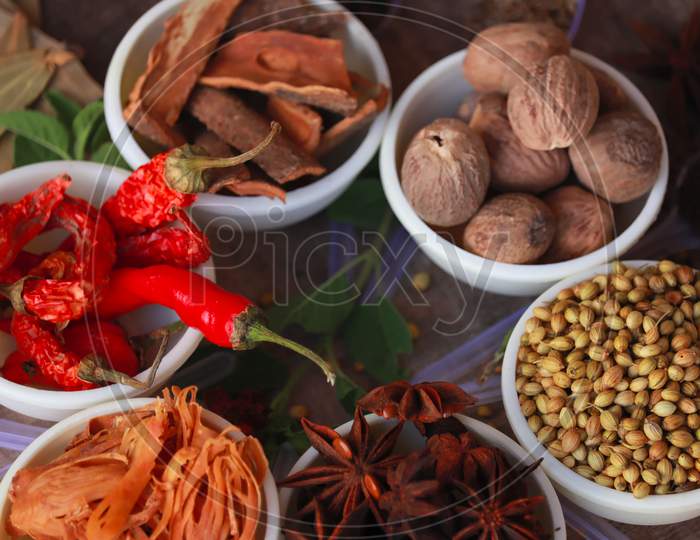 Food And Cuisine Ingredients,Colourful Various Herbs And Spices For Cooking,Indian Spices,Rotation All Indian Spices On Wooden Table, Jaiphal, Star Anise, Chakri Fool, Cardamom, Elaichi, Saunf