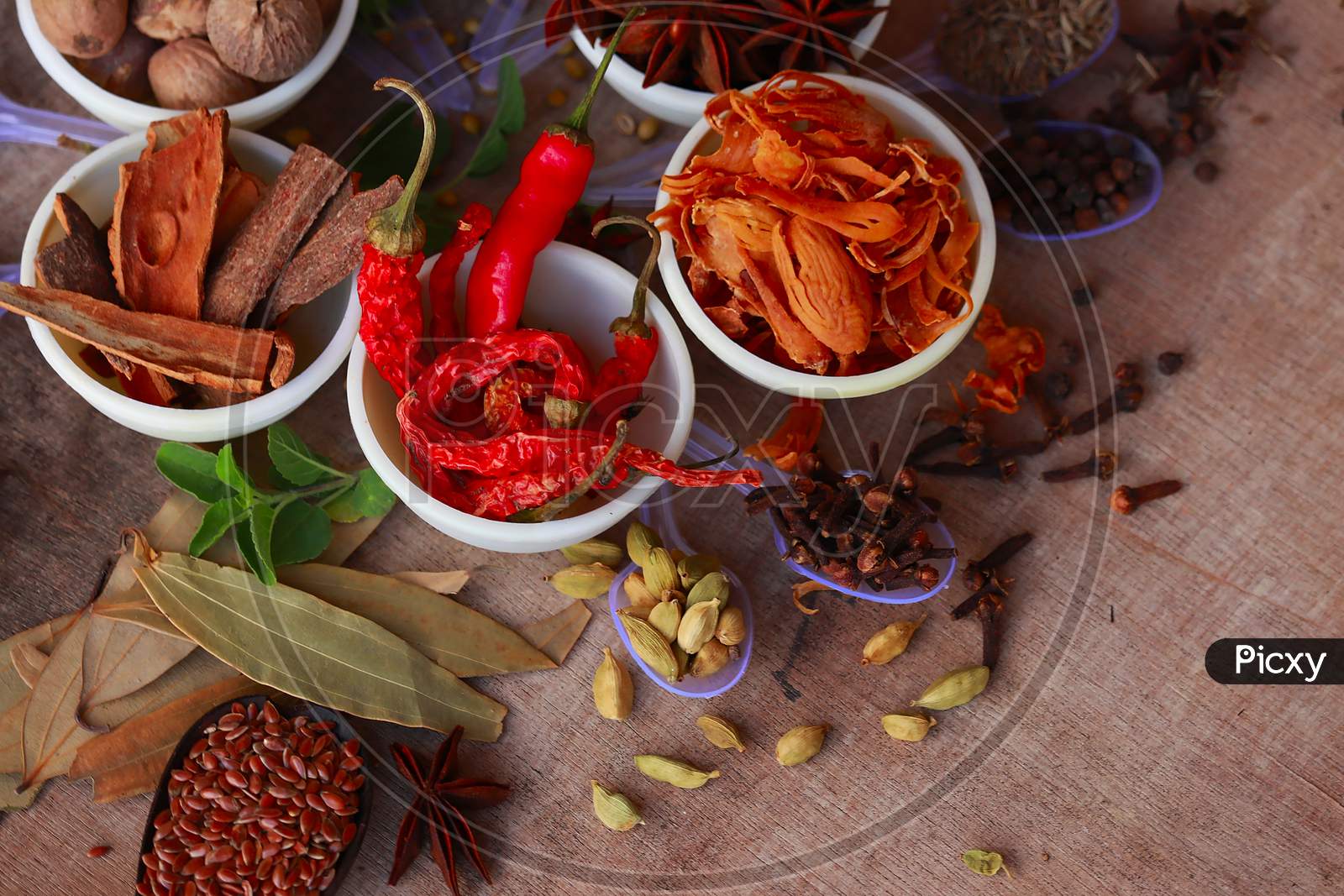 Spices And Herbs On Kitchen Or Wooden Table,Colorful Spices And Herbs For Cooking With Rotation Teblet, Jaiphal, Star Anise, Chakri Fool, Cardamom, Elaichi, Saunf,Background Rotating,