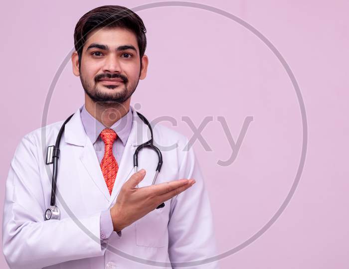 Young Doctor Holding Something In Empty Hand Isolated Background.