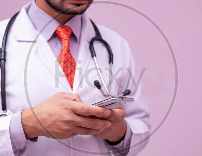 Medical App. Smartphone In Hands Of  Male Doctor On Isolated Background, Selective Focus On Device.