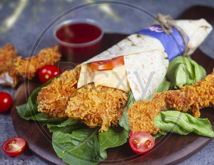 Fresh Fried Chicken Roll With Fresh Tomatos, Salad, Cheese And Onions Isolated On Bright Blue Background. Side View.Selective Focus