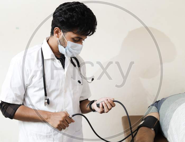 Indian Doctor checking patient arterial blood pressure. Health care concept