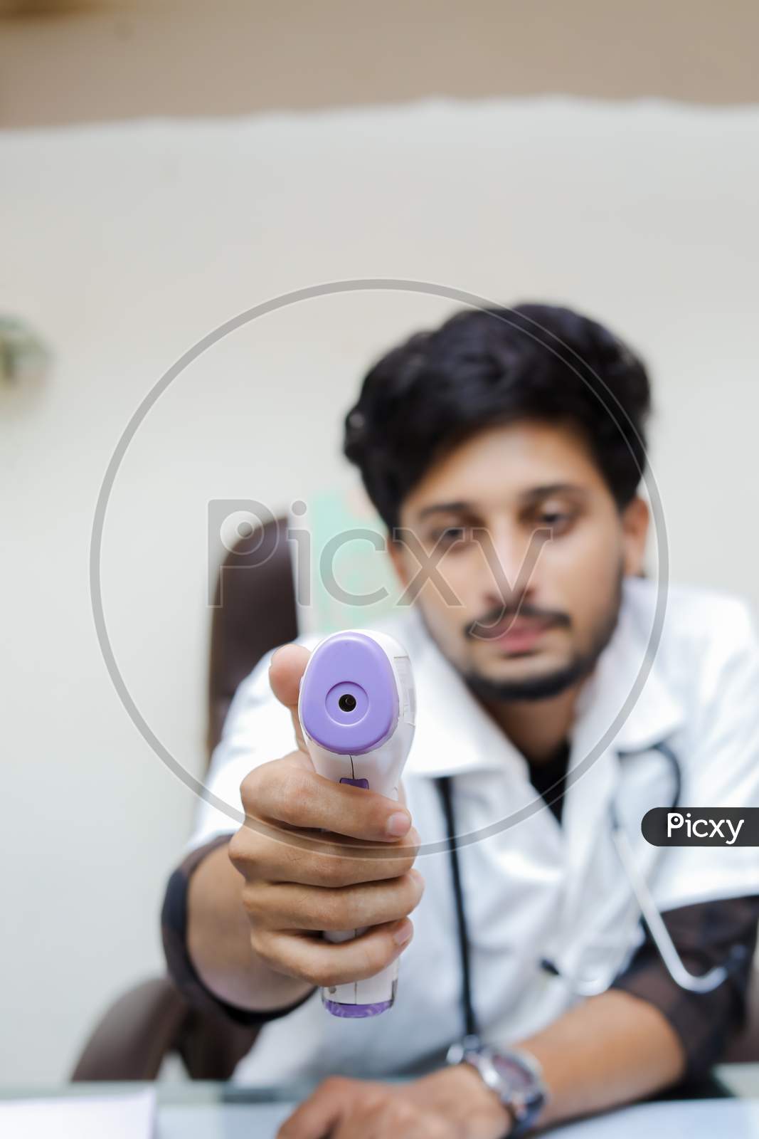 Doctor in a mask protective mask use infrared forehead thermometer to check body temperature for virus symptoms. Thermometer gun. Virus concept. Coronavirus.