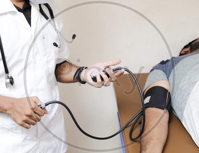 Indian Doctor checking patient arterial blood pressure. Health care concept