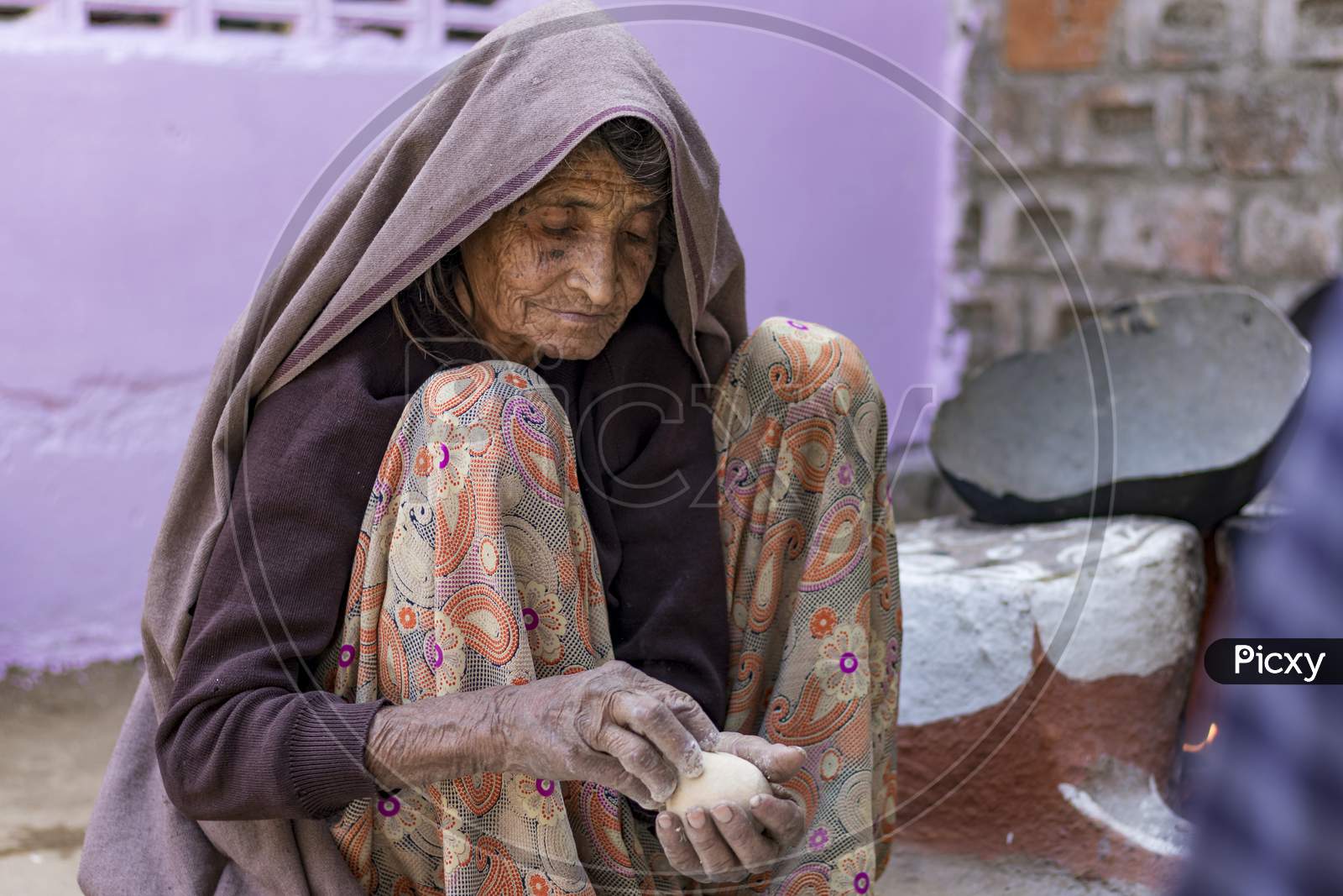 An Indian Old Age Woman Making Food For Family In Rajasthan, India