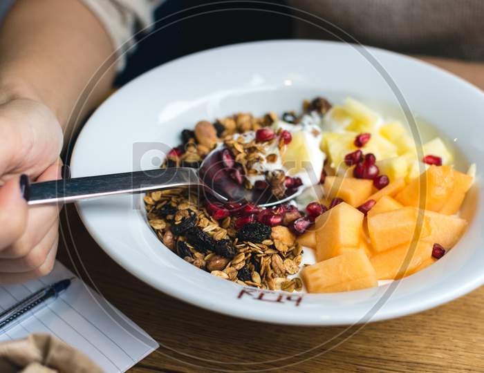 Eating Granola With Fresh Fruits At Restaurant