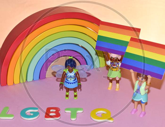 Vaduz, Liechtenstein, October 17, 2021 Human Toys With Gender Flags In Front Of A Rainbow