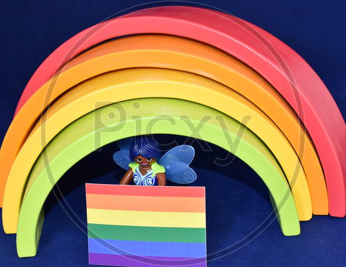 Vaduz, Liechtenstein, October 15, 2021 Angel Toy With A Gender Flag In Front Of A Rainbow