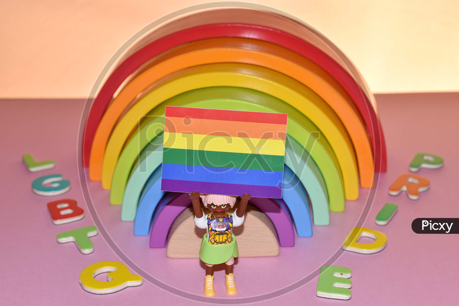 Vaduz, Liechtenstein, October 17, 2021 Human Toy With A Gender Flag In Front Of A Rainbow