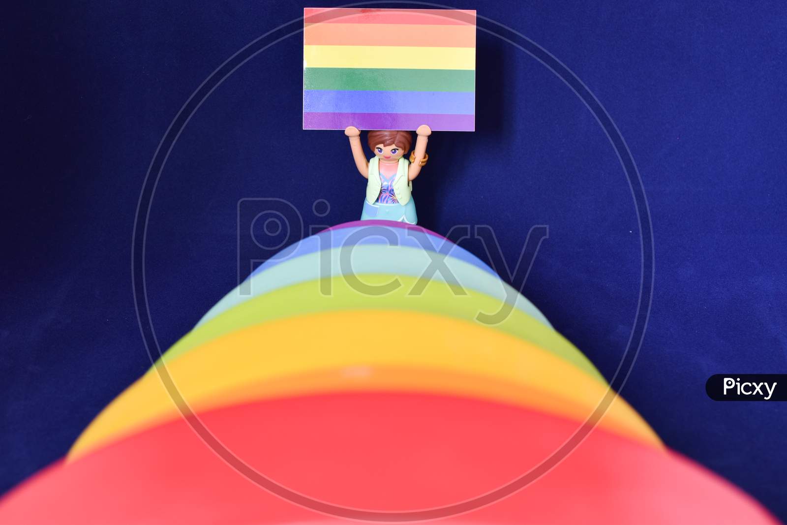 Vaduz, Liechtenstein, October 15, 2021 Human Toy With A Gender Flag Behind Rainbow Colors