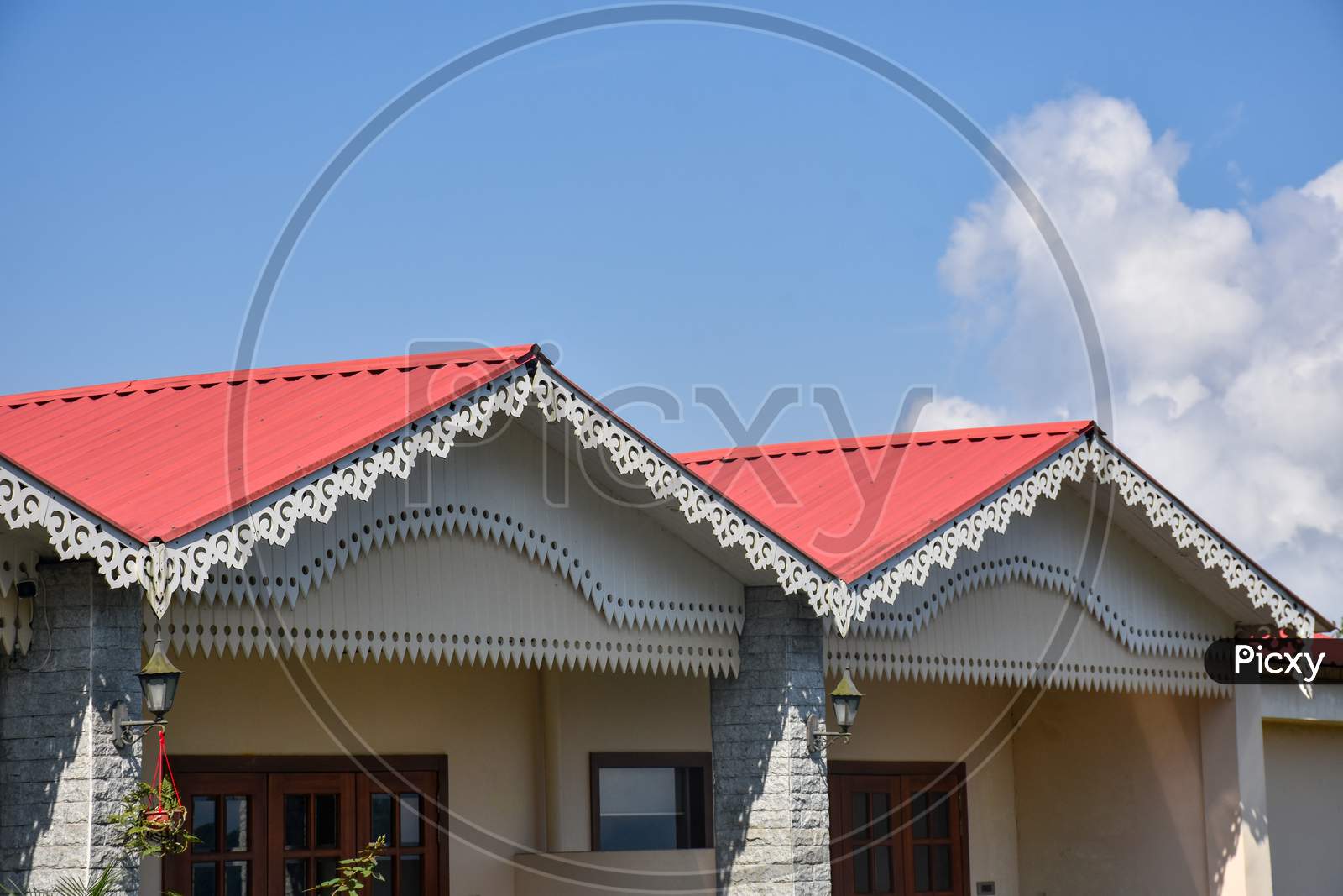 Beautiful Red Alpine Metallic Roof And Blue Cloudy Sky